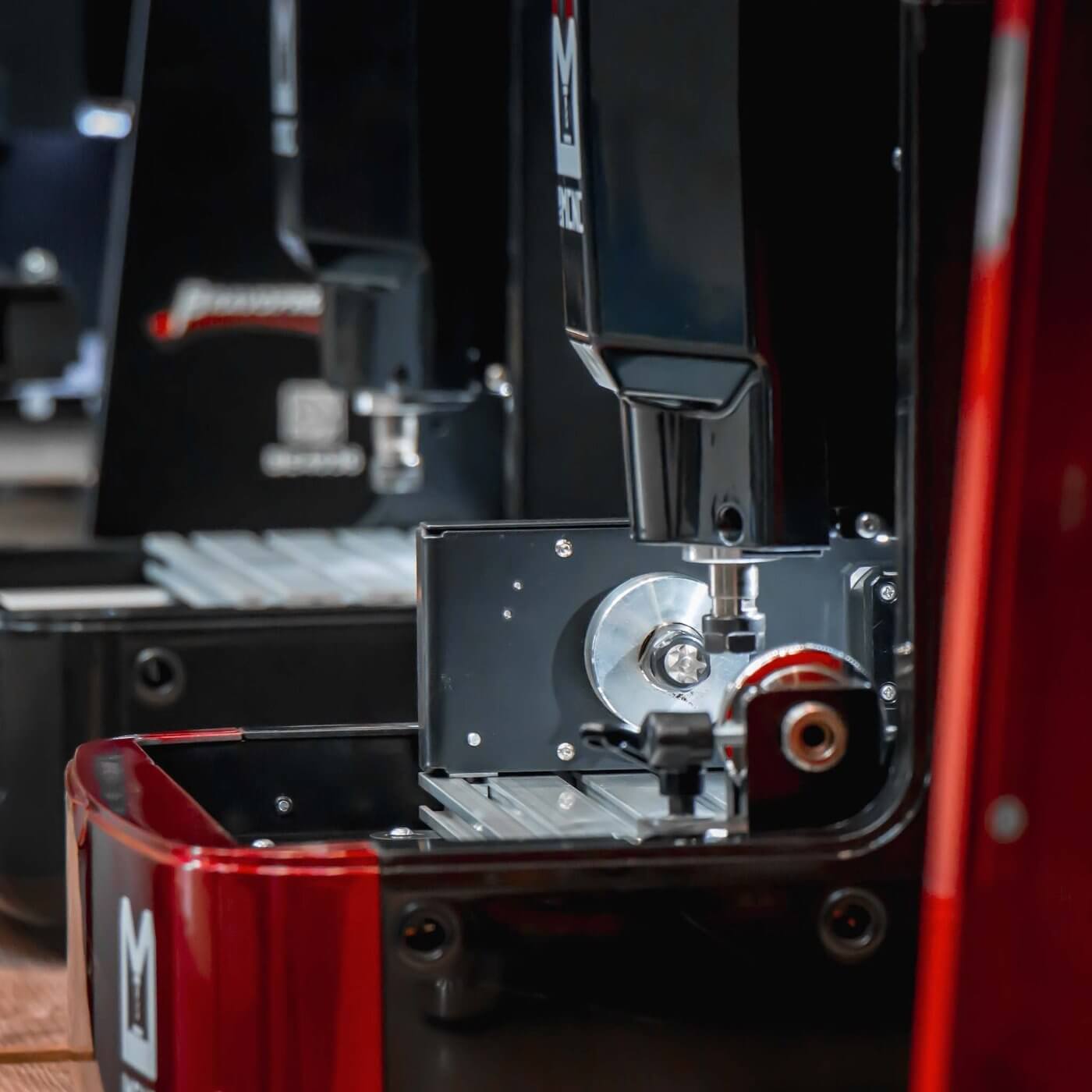 Close-up of IMCNC mini CNC machine with rotary axis attachment installed, red frame and spindle in view, designed for cylindrical engraving.