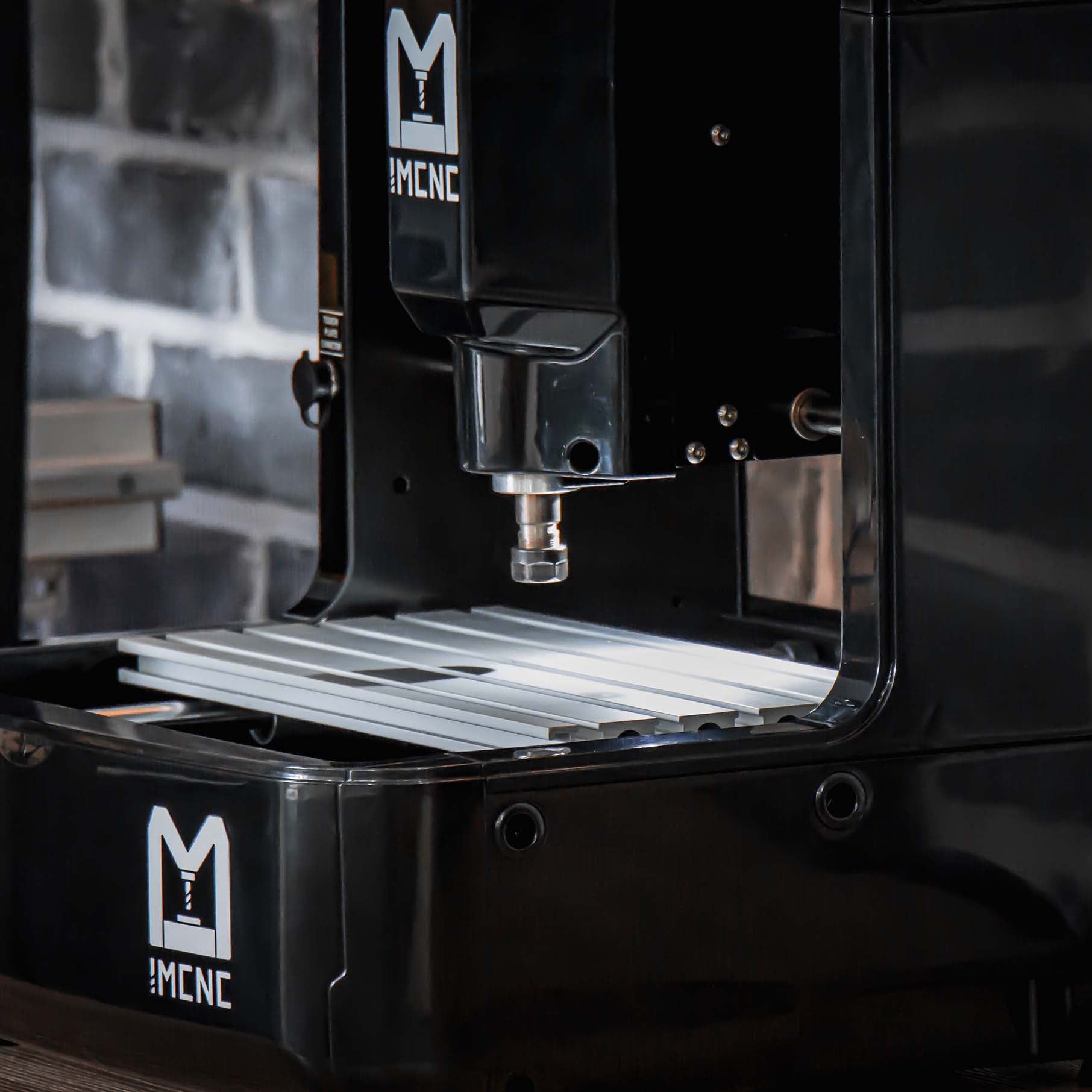 Front view of IMCNC mini CNC engraving machine with spindle positioned above flat aluminum work bed, ready for engraving.