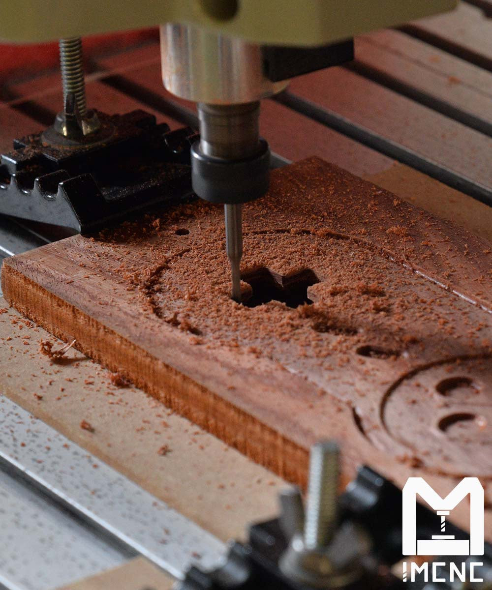Compact size CNC machine engraving detailed button shapes into wood with ER11 collet bits.
